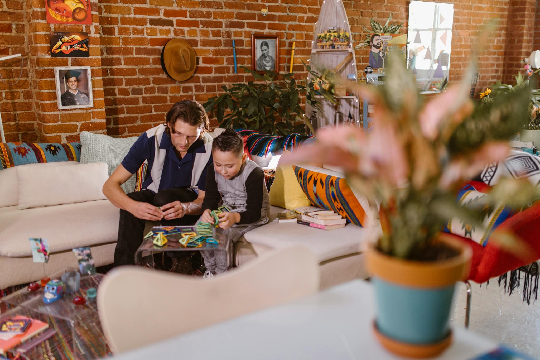 A father and son building with magnetic blocks in a cozy living room setting.