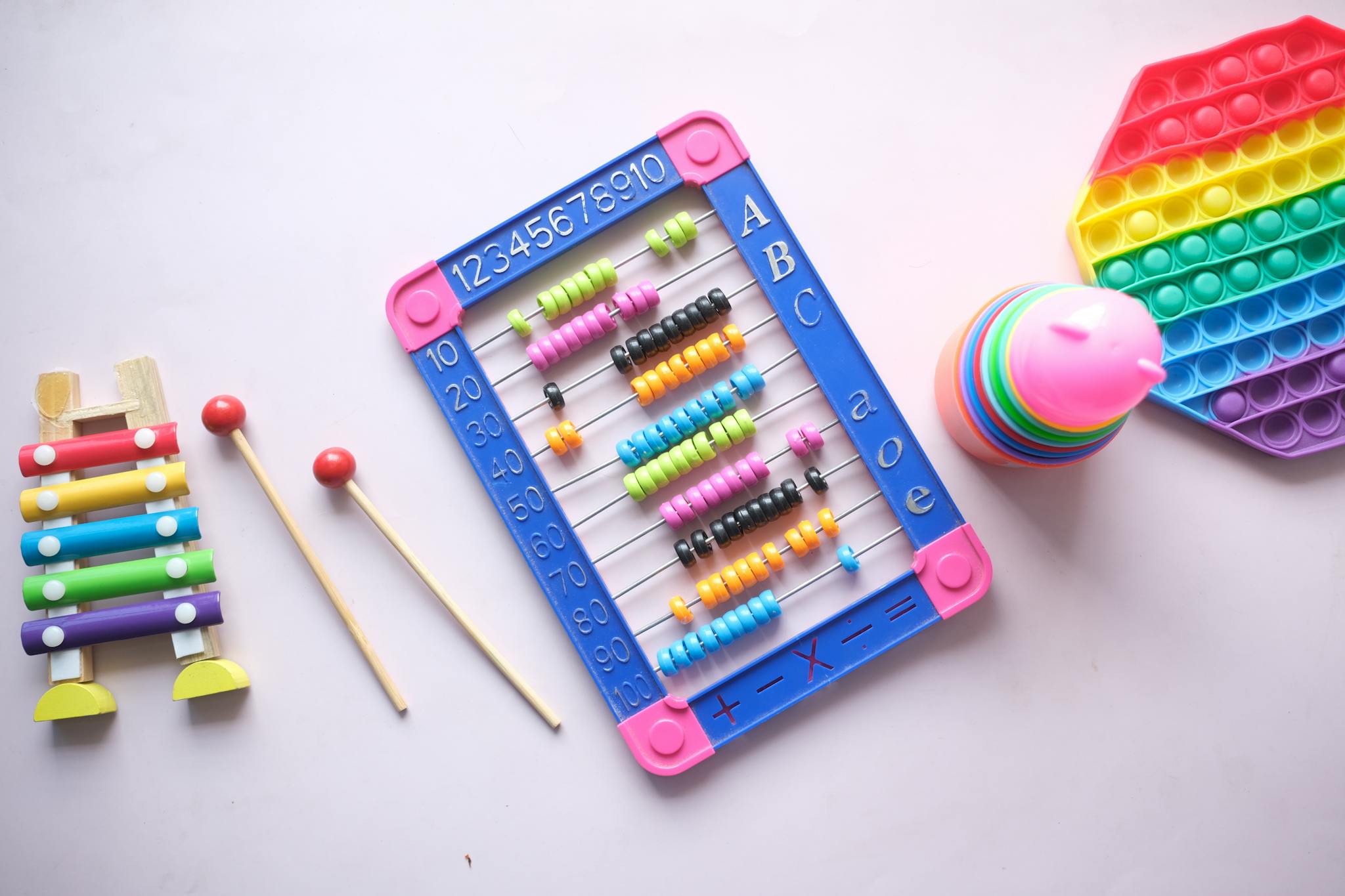 A vibrant display of educational toys including an abacus, xylophone, and stacking cups for children.