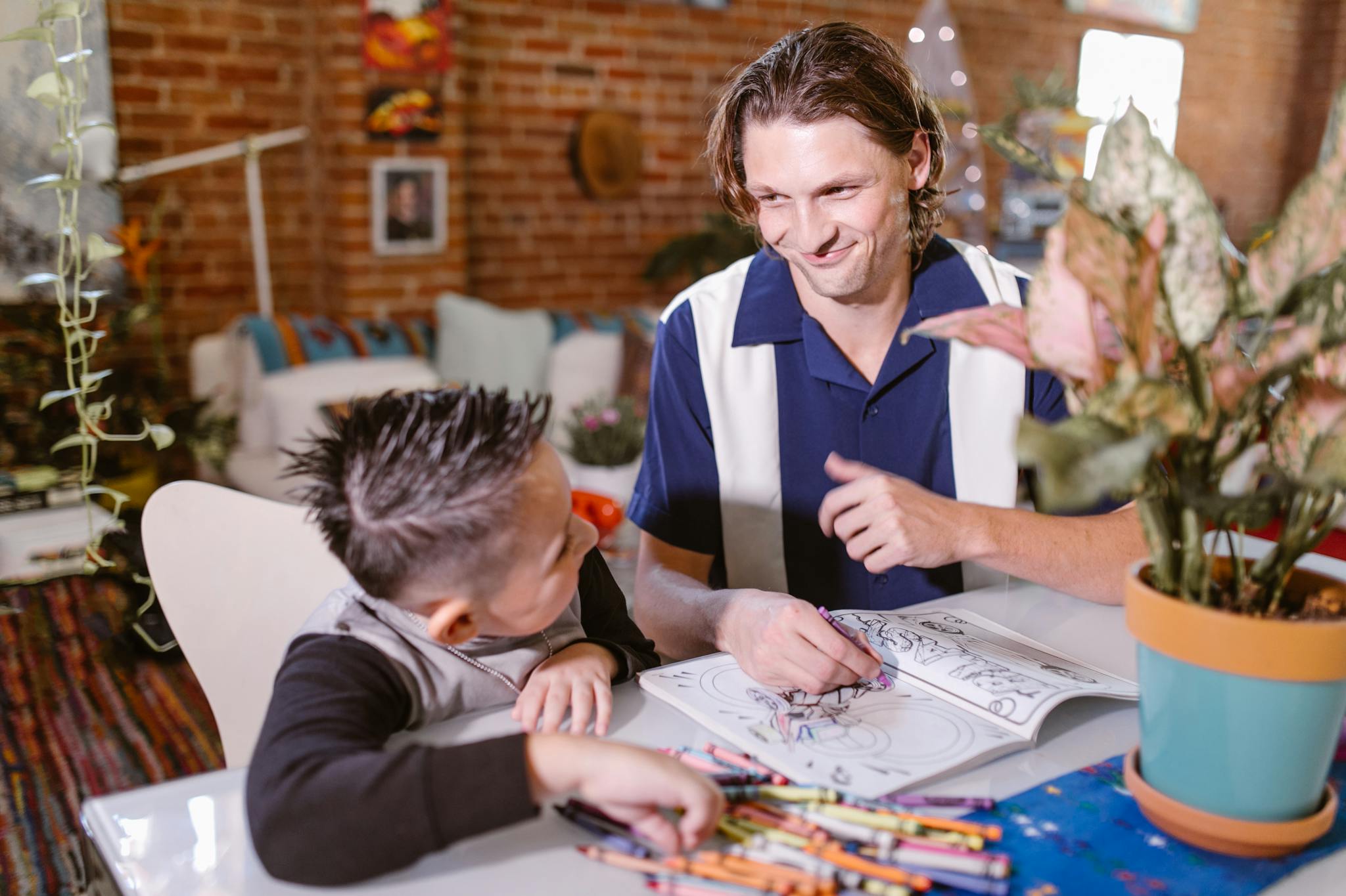 Father and son enjoying creative drawing time at home, fostering bonding and early childhood education.